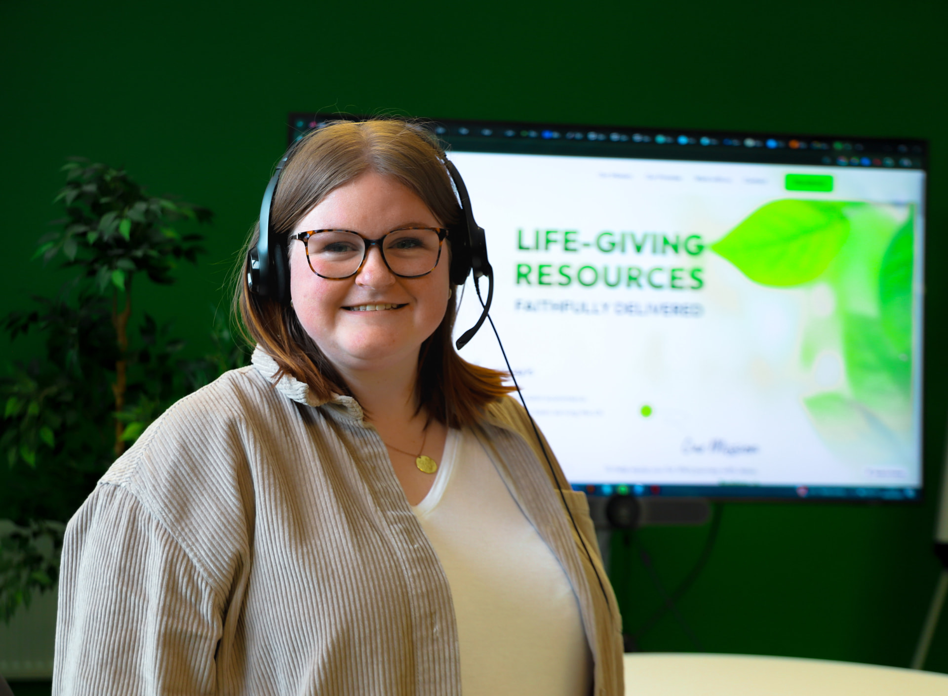 An Eden customer care adviser wearing a headset at her desk