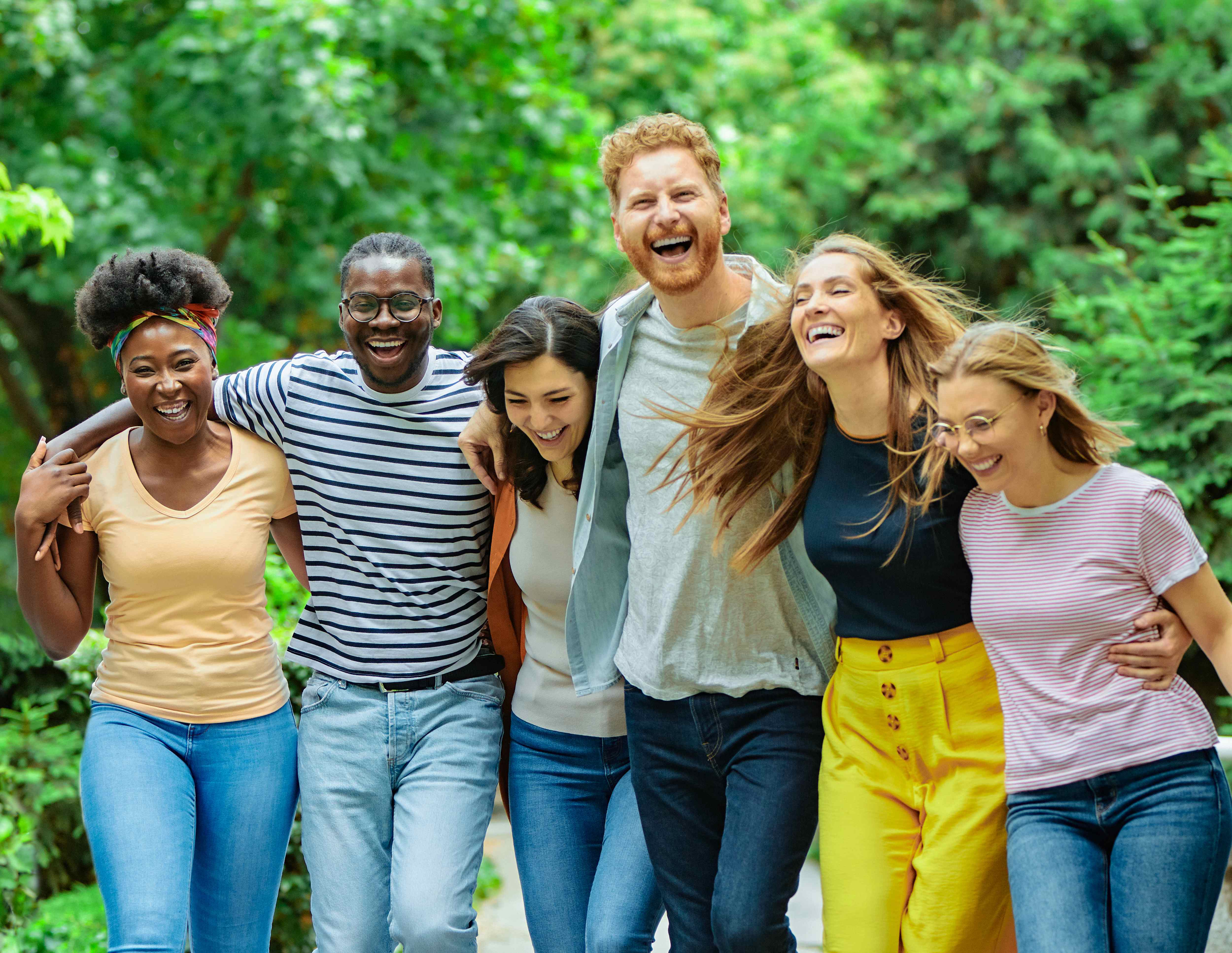 A diverse group of people laughing together outdoors
